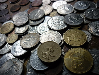 Close-up of mixed international coins on wooden surface