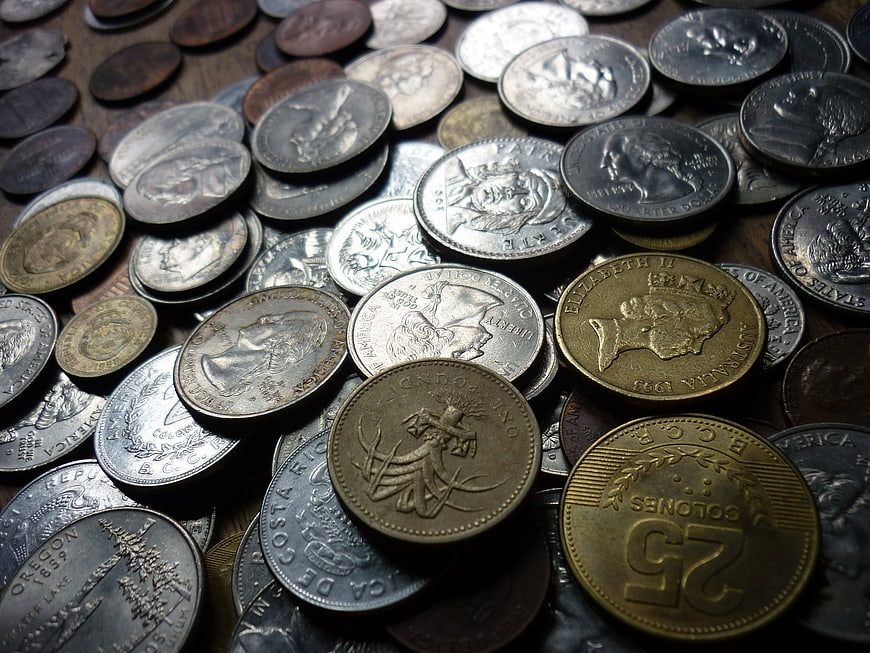 Close-up of mixed international coins on wooden surface