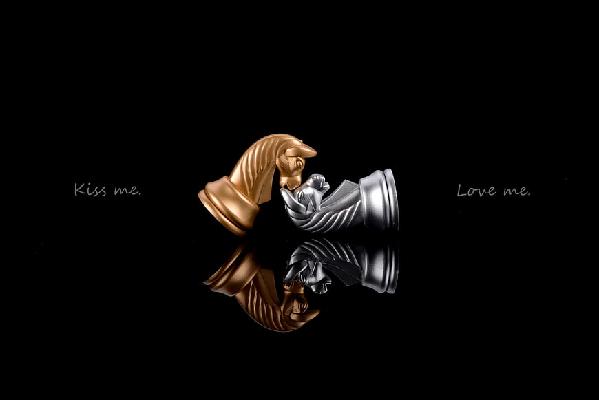 Gold and Silver Chess Pieces Kissing on Black Background