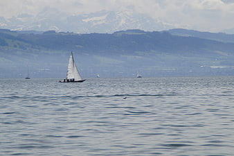 Sailboat on Lake Constance with Alpine Mountains Background