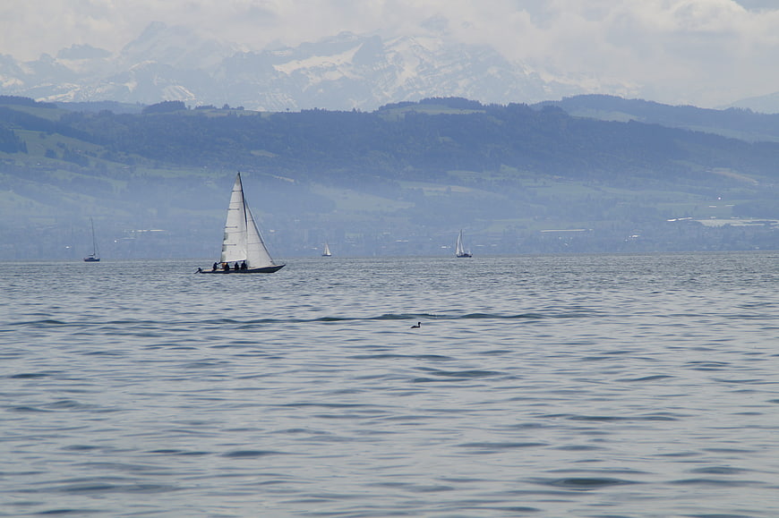 Sailboat on Lake Constance with Alpine Mountains Background