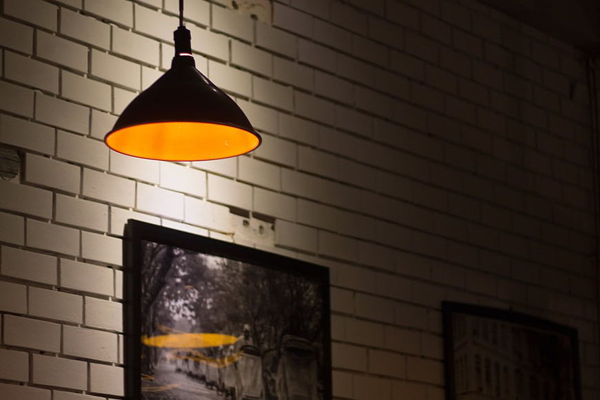 Vintage industrial pendant lamp on white brick wall