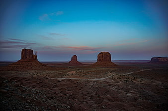 Monument Valley buttes at twilight with winding dirt road