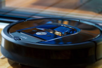 Close-up of a black robotic vacuum cleaner on a wooden floor