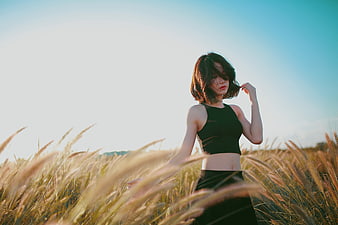 Woman in Black Outfit Standing in Golden Grass Field