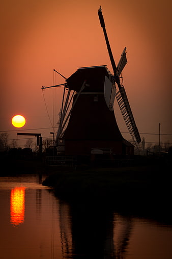Silhouette of Dutch Windmill at Sunset Over Canal