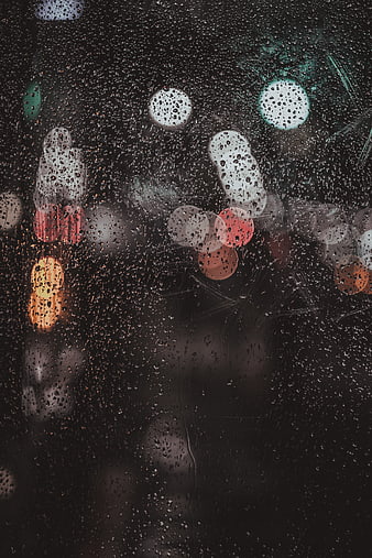 Raindrops on Glass with Blurred City Lights at Night