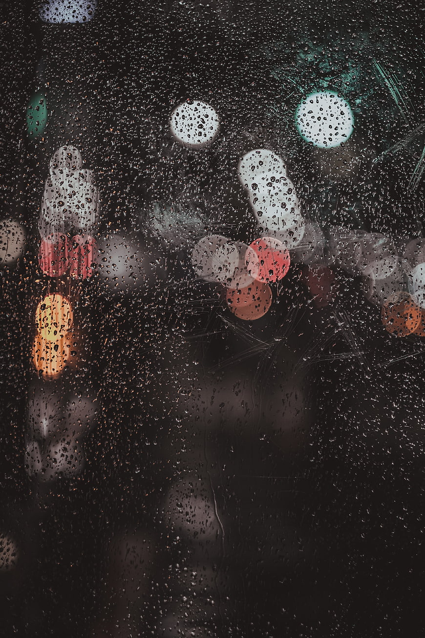 Raindrops on Glass with Blurred City Lights at Night