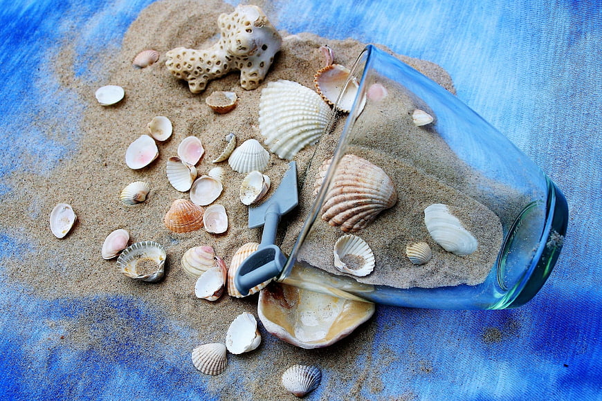 Spilled Sand and Seashells in Blue Glass on Blue Fabric