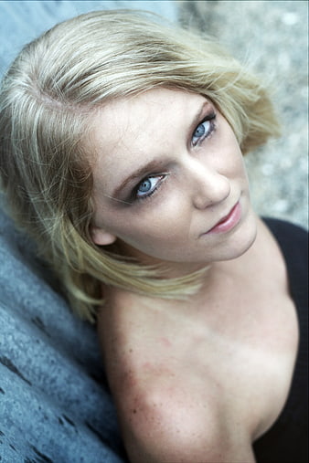 Close-up portrait of blonde woman with blue eyes looking up