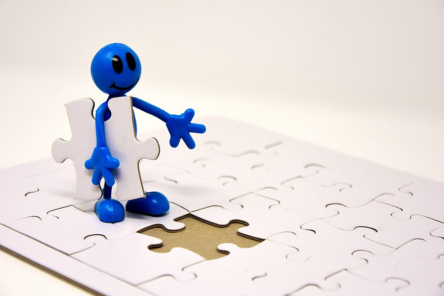 Blue figure holding puzzle piece over missing spot