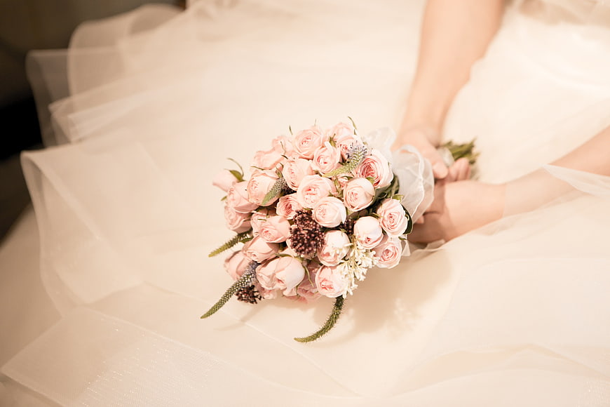 Bride Holding Soft Pink Rose Wedding Bouquet on White Tulle Veil