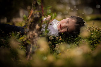 Cute little girl lying in grass with clover flowers