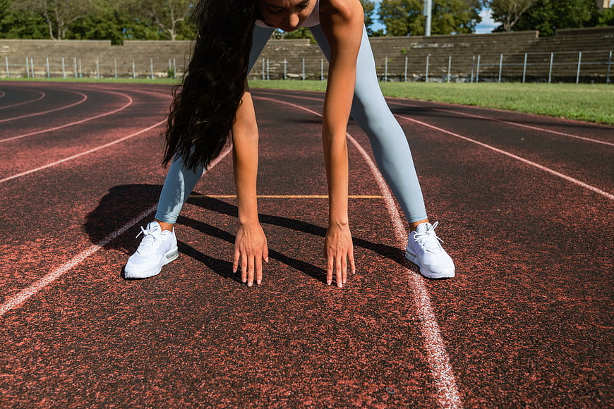 Female Athlete in Starting Position on Running Track