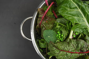 Fresh Mixed Greens and Peas in Metal Colander