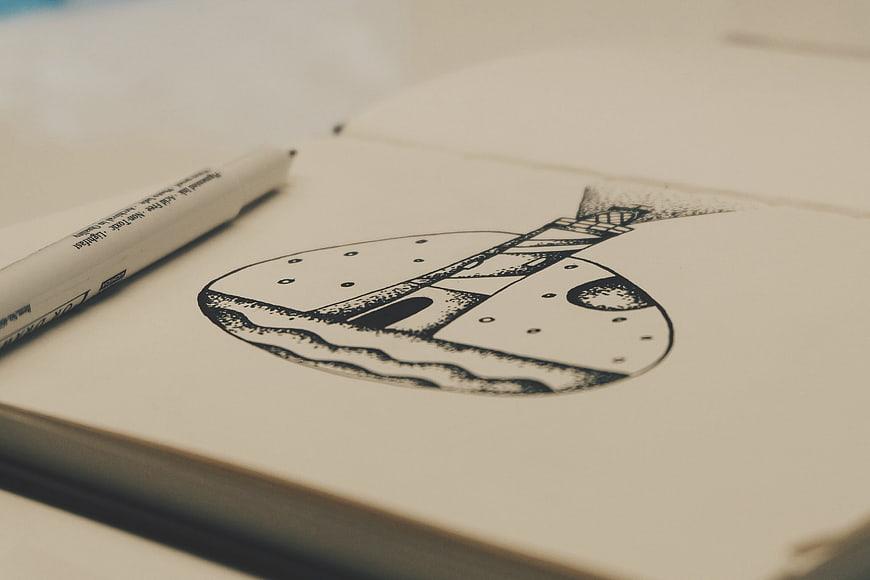 Hand-drawn lighthouse sketch in notebook with pen