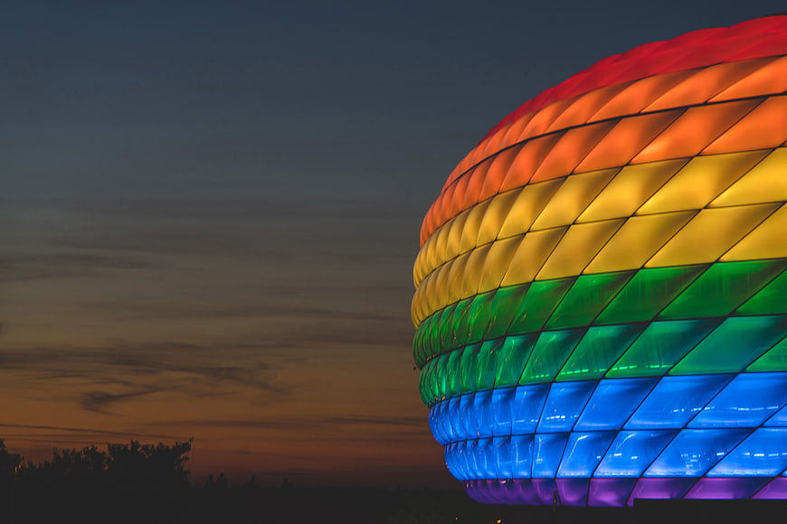 Rainbow illuminated stadium architecture at dusk