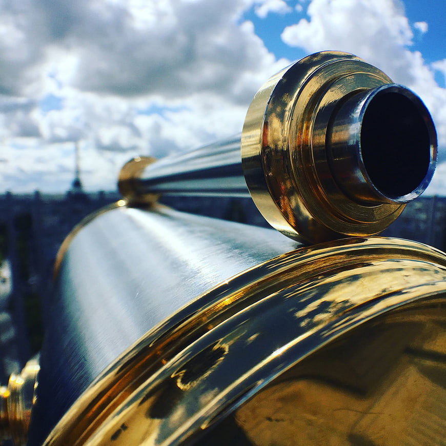Close-up of brass telescope overlooking Paris cityscape