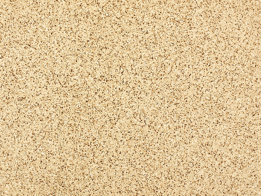 Close-up beige sand texture background with granular detail