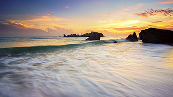 Serene Sunset Ocean Waves Crashing on Rocky Beach