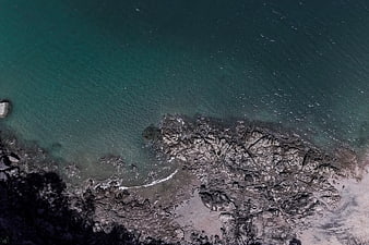 Aerial View of Rocky Coastline with Turquoise Ocean Water