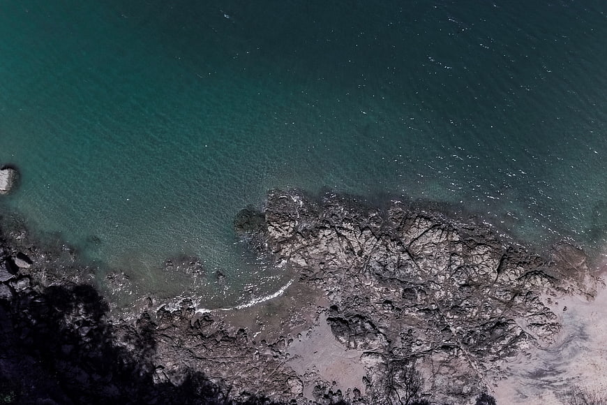 Aerial View of Rocky Coastline with Turquoise Ocean Water