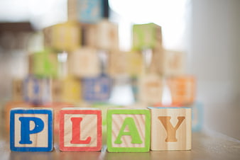 Wooden blocks spelling PLAY on a table