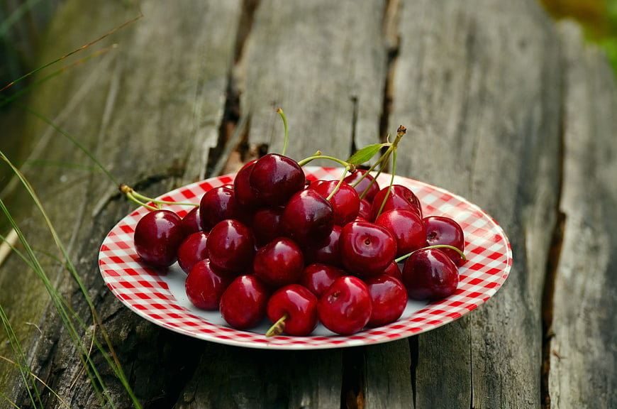 Fresh Red Cherries on Checkered Plate on Wood