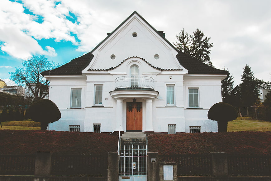 Symmetrical White Villa with Wooden Door and Blue Sky