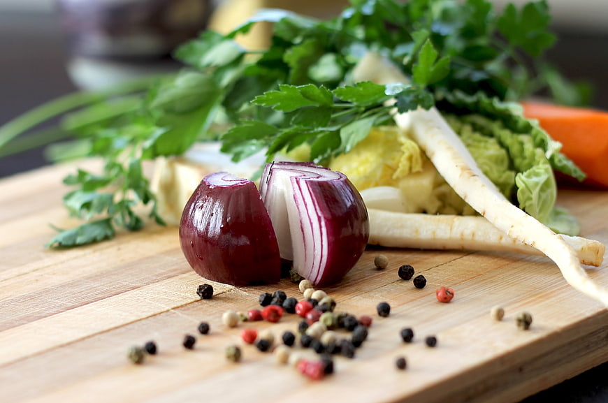Fresh vegetables and spices on wooden cutting board