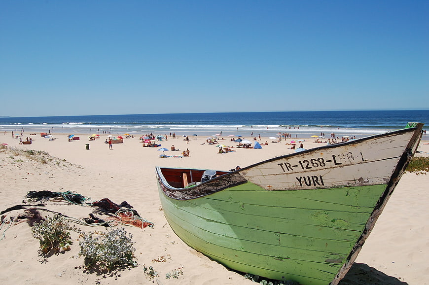 Green Fishing Boat on Sandy Beach with Ocean View