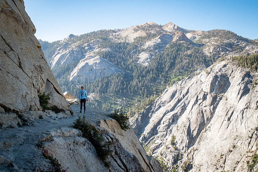 Woman hiking on rocky mountain trail with scenic view
