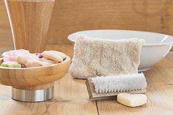 Natural bath accessories with soap, brush, and towel on wood