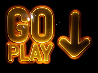 Glowing yellow neon sign reading Go Play with arrow