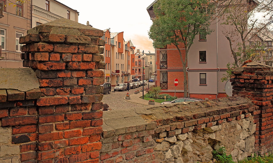 Old brick wall framing cobblestone street in historic European town