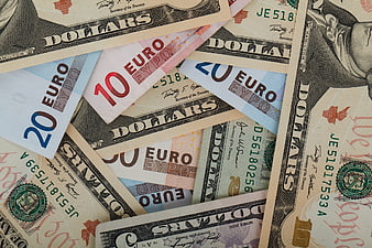 Scattered US Dollars and Euro Banknotes Background