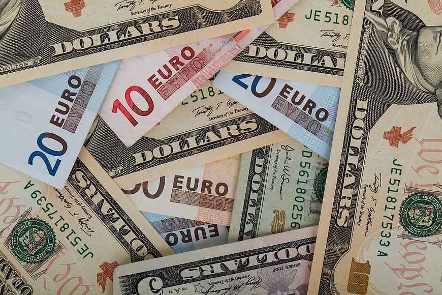 Scattered US Dollars and Euro Banknotes Background