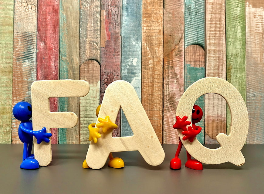 FAQ Concept With Wooden Letters And Colorful Plastic Figures