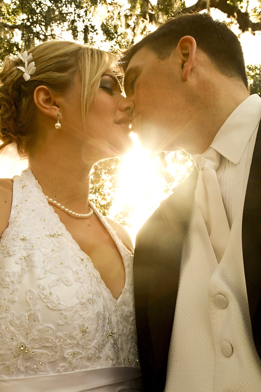 Bride and Groom Kissing with Sun Flare