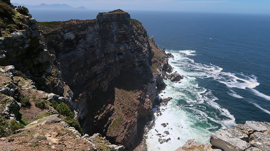 Dramatic coastal cliffs meeting the ocean with crashing waves