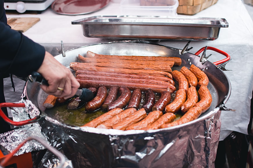 Cooking Sausages in Large Pan at Outdoor Market