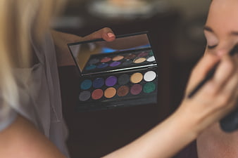 Makeup artist applying colorful eyeshadow palette