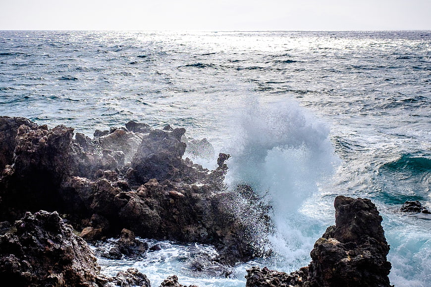 Powerful ocean waves crashing against dark rocky coastline