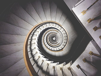 Top-down view of elegant spiral marble staircase with gold accents