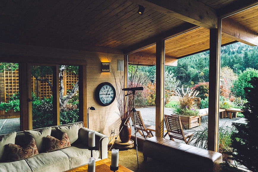 Modern rustic living room with large windows and garden view