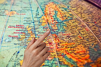 Hand Pointing at Europe on Vintage World Map