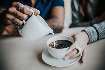 Couple Pouring Milk into Coffee Cup Close Up