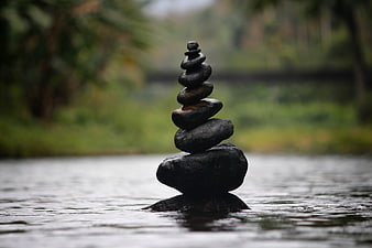 Stacked stones balanced in water for zen and meditation