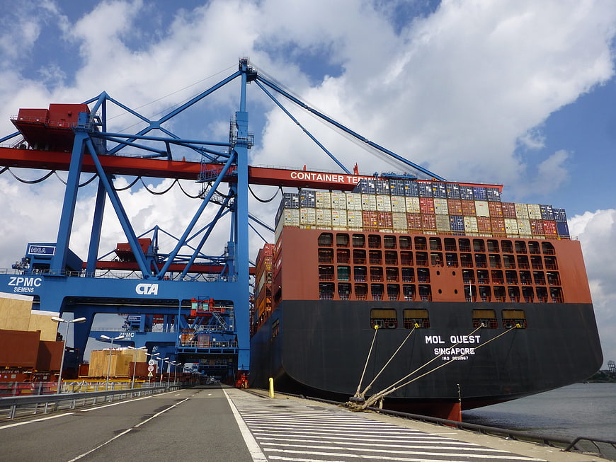 Large Container Ship Docked at Port with Blue Cranes