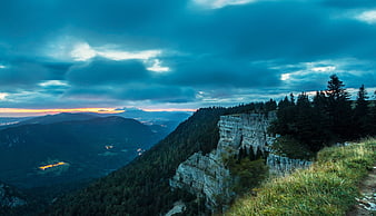 Dramatic Mountain Landscape at Dawn with Distant City Lights